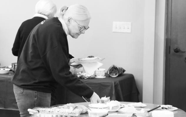 FRIENDS from across Howard County gathered together on Wednesday morning for a potluck meal at the St. Paul Senior Center. Above, Zola Jarecke scouts the dessert table during the meal. A large crowd turned out for the event. Photo by Michael Rother