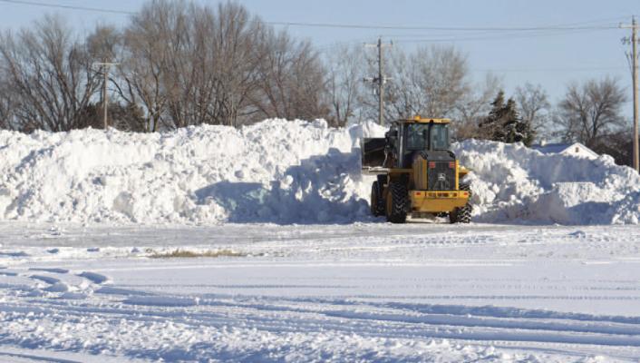 CREWS with the City of St. Paul work to pile snow on an empty lot on Fourth Street last week. A winter storm delivered ice and snow to the area, with the National Weather Service in Hastings officially reporting that over three inches of snow fell in St. Paul. (Michael Happ)