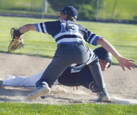 ST. PAUL’S Zandyn Weller attempts to avoid getting picked off at first base by Caden Straka during last week’s game between St. Paul and Palmer-Wolbach-Greeley. Photos by Michael Happ