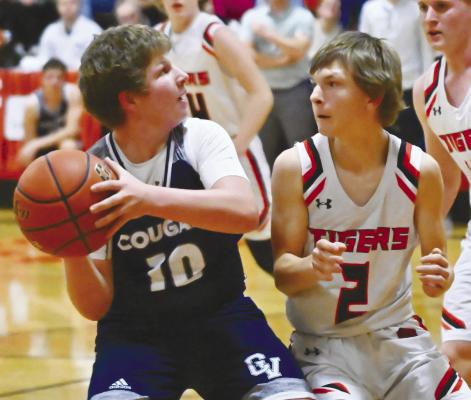 CENTRAL VALLEY’S July Gotschall battles a Palmer defender on his way to the hoop during the fourth quarter of last week’s game between the Cougars and the Tigers. Photo by Michael Happ