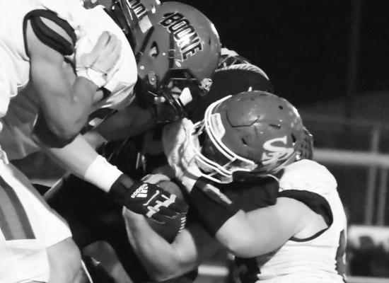 CODY KUSZAK keeps a tight grip on the football while being bombarded by Boone Central defenders Friday night. The Cardinals topped the Wildcats 23-7 last week. Photos by Michael Happ