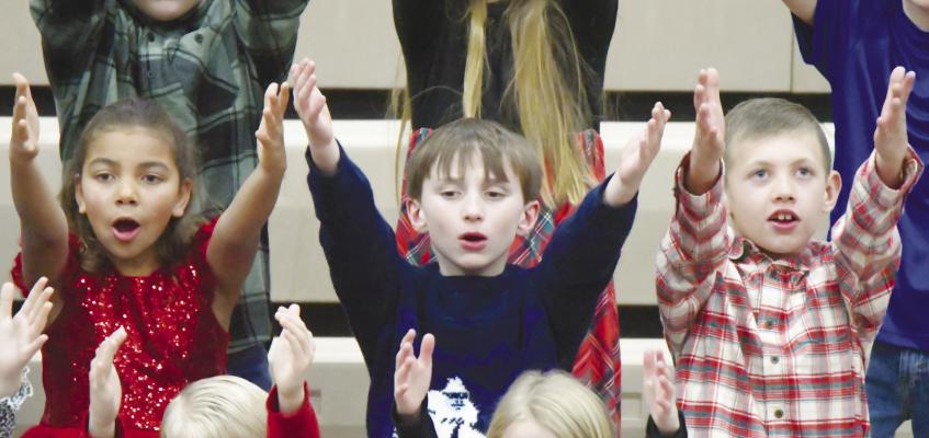 ST. PAUL ELEMENTARY SCHOOL held its annual holiday program last Thursday evening. A large crowd filled the high school gymnasium for the annual event, which highlighted students in kindergarten, first, second, third, and fourth grades. Pictured above are third-graders J’Nehya Saathoff, Asher Knapp, and Carter Muller. Photo by Michael Happ