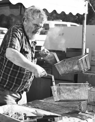 THE ELBA VOLUNTEER FIRE DEPARTMENT held its annual Mountain Oyster Feed on Saturday night in Elba. A large crowd of hungry patrons attended the event, with lines forming outside the fire hall to get a plate and snag a seat. Above, Jeff Beeler helps man the fryers during the event. Below, Jeff Spiehs deposits some freshly fried mountain oysters into a tray to be served to the line of hungry patrons who attended last week’s fundraiser. Photos by Michael Happ