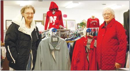 VOLUNTEER CAROLYN JUST AND MANAGER THEDA VAN HORN pose inside of the Howard County Hospital A uxiliary Thrift Shop while modeling two of the coats the shop will be giving away in early October. Photo by Michael Rother
