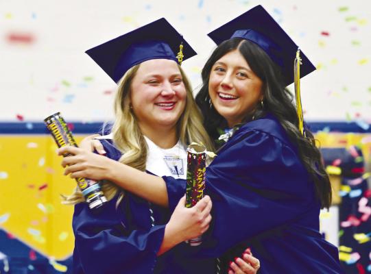 ST. PAUL graduates Brooke Peetz and Ava Vech embrace prior to exiting the gymnasium during Sunday’s commencement exercises at St. Paul High School. Photos by Michael Happ
