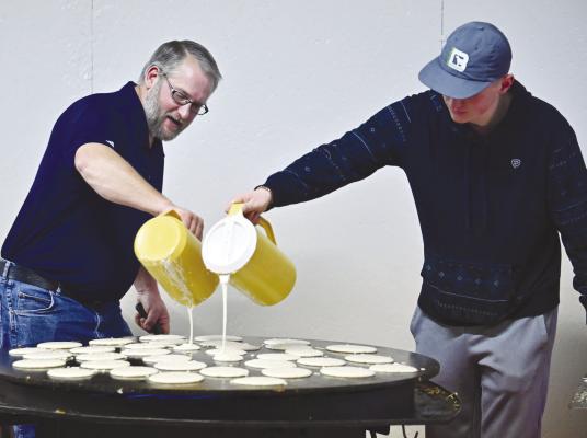 HELPING MAN THE GRIDDLE during the 4-H Pancake Feed at the Howard County Fairgrounds on Sunday were Joe Smydra and Cole Brus. Pancakes, the focal point of the Sunday morning event, were accompanied by many other breakfast staples. Photo by Michael Happ