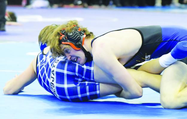 ST. PAUL’S KALEB BAKER works to turn Pierce’s Brenden Bolling during Saturday morning’s consolation semifinal round of the NSAA State Wrestling Championships in Omaha. The Wildcat won a 4-0 victory from the Bluejay. (Michael Happ)
