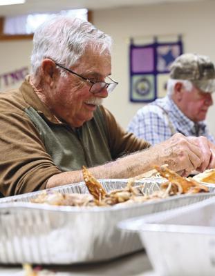 VOLUNTEERS worked to prepare the fifteen turkeys that were cooked for last Thursday’s community Thanksgiving dinner last Wednesday. Among those that lent a hand was Phil LaRoe. Photo by Michael Happ