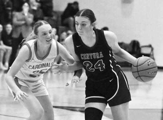 KENNEDY DAVIS drives past Doniphan-Trumbull’s Kendall Posey during the second quarter of last Tuesday night’s matchup between the Centurions and the Cardinals in Doniphan. Davis scored seventeen points in Centura’s 58-23 victory.