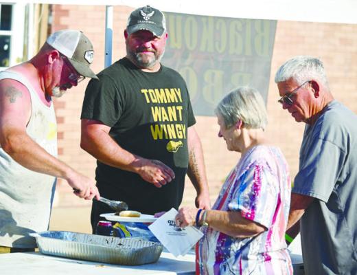 STEVE KOSMICKI serves up some barbecue to Mary and Neal Trentman during last Saturday’s barbecue cookoff hosted by the Howard County Senior Citizens. Photos by Michael Happ