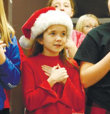 ST. PAUL ELEMENTARY SCHOOL fifth graders performed carols in Matelyn Retirement Community last Friday morning. Above, Cami Taylor sings for the residents.