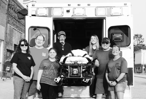 THE WOLBACH VOLUNTEER FIRE DEPARTMENT AND EMTS purchased a new ambulance cot and fastener system in 2023. Firefighters and EMTs pictured with the new cot include Ann Wadsworth, Rick Brown, Beckie Brown, Ron Tubbs, Kortney Daniels, Patrick Killinger, and Trish Nelson. Photo by Michael Rother