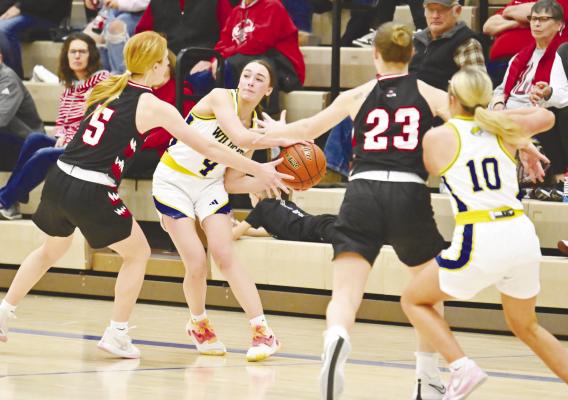 ADDY WEGNER passes the ball to Alli Dugan in the fourth quarter of last month’s basketball game between St. Paul and Arcadia/Loup City. The Wildcats won the game 49-36. Photo by Michael Happ