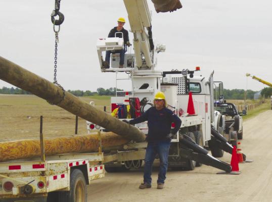 CREWS with Howard Greeley Rural Public Power District—including Cody Kaczor and Robert Svoboda—work to repair power infrastructure in southern Howard County following last month’s destructive tornado. Courtesy Photo