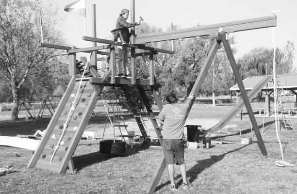 NEW PLAYGROUND EQUIPMENT was installed at Cottonwood Park and at the mini park next to the Wolbach Community Center last week thanks to the Wolbach Community Club and the Dawsyn Rother Memorial Foundation. Pictured above, employees with Backyard Playworld can be seen installing the equipment at Cottonwood Park on Friday morning. Photo by Michael Rother