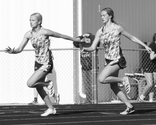 ALEXIS JOHNSON makes the final exchange with Taylor McIntyre in the girls’ 4x100-meter relay last Wednesday at the District D-5 Meet in Fullerton. The Cougars won that race in 51.85. Photos by Michael Happ