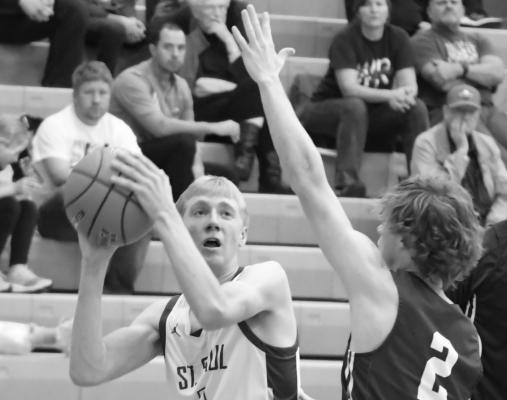 ST. PAUL senior Sam Wells ducks past a Wood River defender on his way to the rim in the fourth quarter of last Thursday night’s game against the Eagles. Photo by Michael Happ