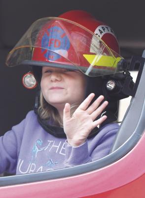 AVERY SAENZ waves to the crowd gathered along Howard Avenue from one of the St. Paul Volunteer Fire Department’s apparatus in Saturday’s parade. Photos by Michael Happ