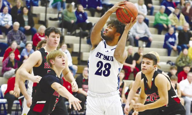 LEVI BADER threads his way past a trio of Arcadia/Loup City defenders on his way to the rim during the first quarter of St. Paul’s game against the Rebels in late December. Photos by Michael Happ