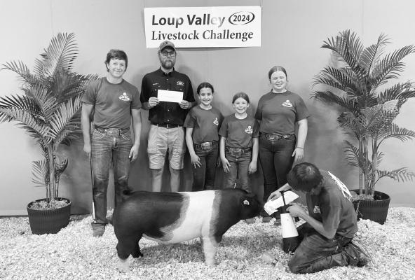 MORGAN JANDA of Ravenna exhibited the third place market barrow during the swine show at the 2024 Loup Valley Livestock Challenge held earlier this year in Ord. Janda’s award was donated by Corteva and presented by Loup Valley Ag Society member Marty Yantzie. Courtesy Photo