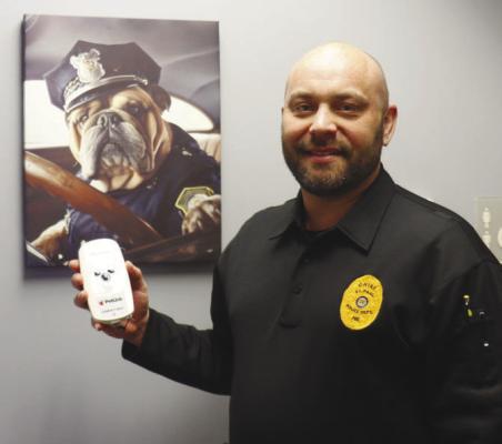 ST. PAUL CHIEF OF POLICE DAN HOWARD shows off his department’s new Petlink Compact Max+. The roughly cell-phone-sized piece of equipment will be instrumental in helping officers more efficiently return the area’s wayward furry companions to their homes. Photo by Michael Rother