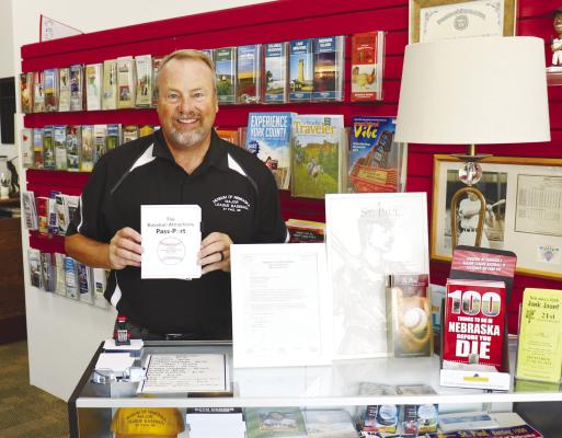 LOREN STUDLEY, a member of the Museum of Nebraska Major League Baseball’s board, shows off a copy of the Baseball Attractions Pass-Port inside the museum last week. Photos by Michael Rother