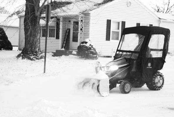 HOWARD COUNTY COURTHOUSE Custodian Pat Koperski works to clear snow from the parking lot at the courthouse early Monday morning. Between one and two inches of snow fell in St. Paul as a result of last weekend’s winter storm.