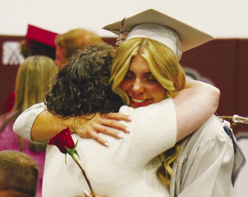 CENTURA graduate Ella Rasmussen embraces a loved one during the rose ceremony portion of last week’s graduation ceremony at Centura High School. Photo by Michael Rother