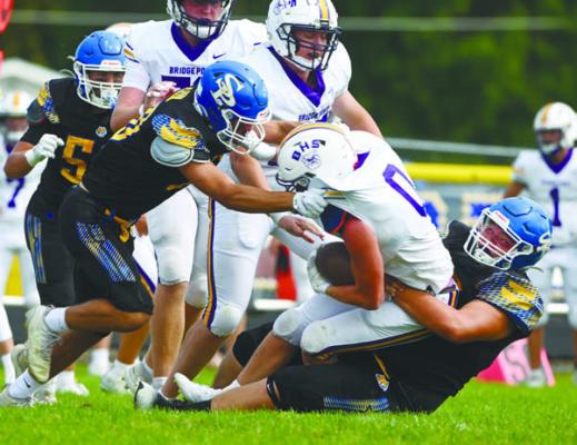 ST. PAUL’S COLTON KUSZAK AND JOEL KASLON work to bring down Daxton Malcolm during last Friday’s game against Bridgeport. Photo by Michael Happ