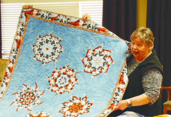 ST. PAUL COUNTRY QUILTERS PRESIDENT JULIE ROSNER presents and discusses a quilt during the St. Paul Country Quilters Quilt Show held at Matelyn Retirement Community earlier this week. Rosner was one of seven to present quilts to the large crowd of gathered residents at the Monday afternoon event. Photos by Michael Rother
