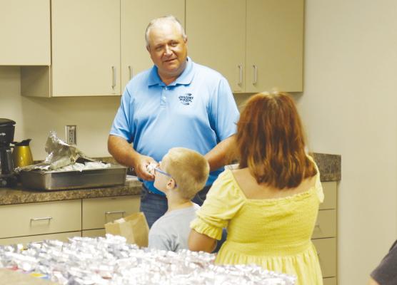 DENNIS WADSWORTH with Citizens Bank and Trust Co. in St. Paul helps out during the Howard Greeley Food Pantry’s Lunch Bunch program last Thursday morning at the Sts. Peter and Paul Catholic Church Parish Life Center. Photos by Michael Rother