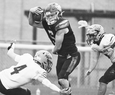 ST. PAUL’S MASON MAJERUS muscles his way past a pair of Summerland defenders on Friday afternoon. The Bobcats beat the Wildcats 24-20, forcing St. Paul to 3-2 on the season. Photos by Michael Happ