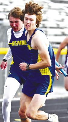 ST. PAUL’S BRECKEN KAVAN makes the second exchange with the Wildcats’ Joel Shafer during the boys’ 4x100-meter relay at the Tom Schacht Invitational at St. Paul High School last week. The Wildcats placed second in that relay behind the boys from Central City. Photo by Michael Happ