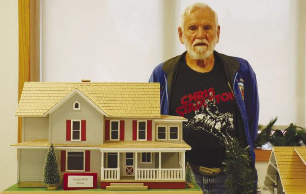 WOLBACH native Paul Nielsen is pictured next to one of the eight structures he made replicating homes in Wolbach. The structures were on display in Wolbach during the community’s Hometown Christmas Celebration earlier this month. Photo by Michael Rother