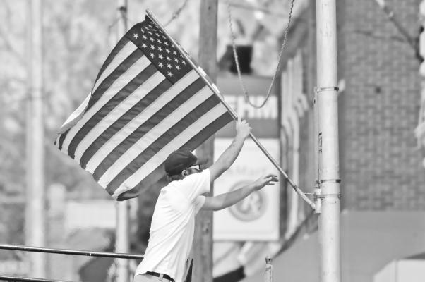 THE CITY OF ST. PAUL got decked out for Flag Day last Friday. Above, Cody Brenick with the city hangs a flag from a pole along Howard Avenue on Friday morning. The city hung the flags on Friday, and they flew throughout the weekend. Photo by Michael Happ