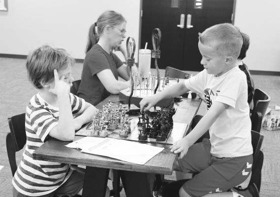 ELLIOTT EGGER AND DALLAS SOLKO play a game of chess at the St. Paul Civic Center during the St. Paul Summer Rec Program’s Chess Club last week. A variety of programs are offered through the annual event each summer. Photo by Michael Rother