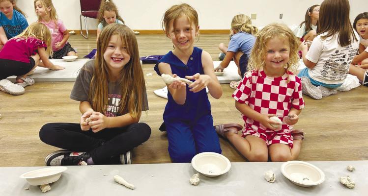 OAKLYNN KLEIN, SCOUT BOWDER, AND RIVERS BOWDER smile as they participate in one of the many fun activities offered at the St. Paul Library as a part of the library’s annual participation in the Summer Reading Program. Courtesy Photo