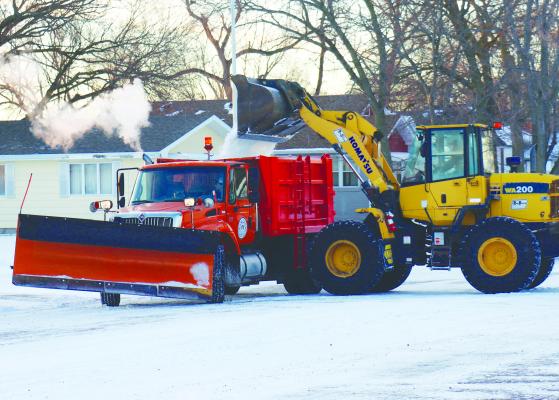 CREWS WITH THE CITY OF ST. PAUL work to clear snow from the city’s streets on Monday morning after a weekend storm dropped around 1.5 inches of snow on the Howard County community. Photos by Michael Rother