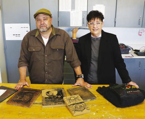 ARTIST IN RESIDENCE Timm Hoff and Art Instructor Catherine Lemmerman stand before several linoleum blocks Hoff has created. Hoff exhibited the blocks to SPPS art students as he taught them about relief printing last week. (Michael Rother)