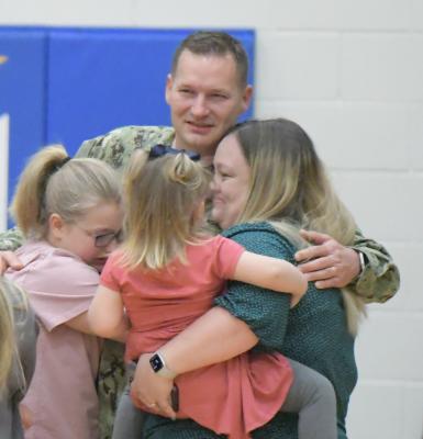 ADAM POWELL was welcomed home by his family during the St. Paul Elementary School’s morning assembly on Friday. Pictured above is Powell, his wife Nekita, daughter Addisyn, and foster child Rachel. (Michael Happ)