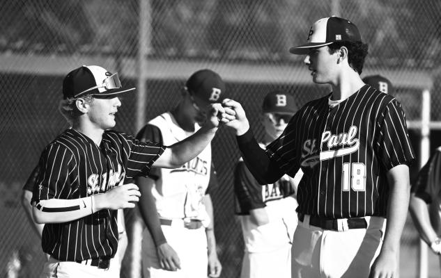ST. PAUL’S COLBY WOOD AND PARKER LENZ share a fist-bump during player introductions prior to the start of Saturday night’s game during the Area C-6 Tournament at Grover Cleveland Alexander Field in St. Paul. Photo by Michael Happ