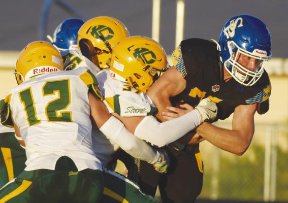 CODY KUSZAK drags several Stars across the field during last Friday night’s game between St. Paul and Kearney Catholic. Kuszak had eleven touches in the contest. Photo by Michael Happ