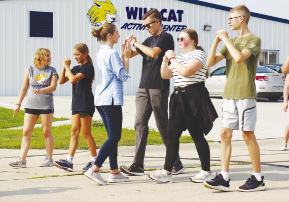 ST. PAUL BAND INSTRUCTOR DANIELLE SPENCER leads members of the high school band in a drill on Grand Street last Thursday. Photos by Michael Rother