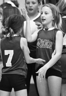 ST. PAUL’S YOUNGEST VOLLEYBALL PLAYERS and fans were on hand to help cheer the Wildcats to victory last Tuesday night during St. Paul’s regular season conference match-up against Central City. Those participating in youth night were treated to a Wildcat sweep of the Bison. Above, Emily Platek exchanges high fives prior to the match. Photo by Michael Happ