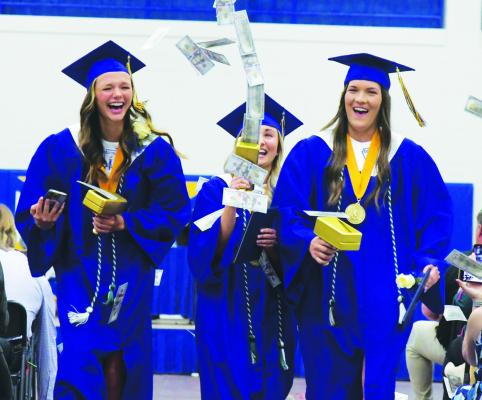 ST. PAUL GRADUATES Paytyn Larsen, Teegan Anderson, and Jenna Jakubowski celebrate as they make their way out of the gymnasium on Sunday afternoon. (Michael Happ)