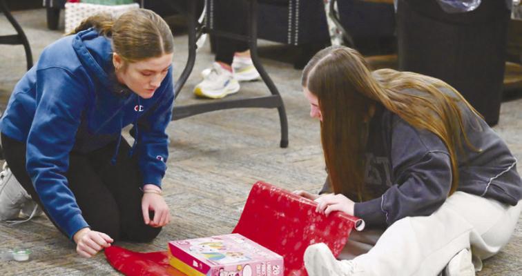 MEMBERS of Rotary Club of St. Paul’s Interact Club—including Hadley Quinn and Tessa Dugan—worked to wrap presents at the St. Paul Civic Center earlier this month. This year’s gift wrapping fundraiser is already off to a strong start, with another date yet to come. Photos by Michael Happ