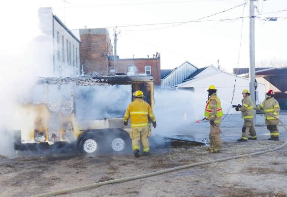 VOLUNTEERS with the St. Paul Volunteer Fire Department extinguish a fire in the alley between Seventh and Eighth streets in St. Paul on Tuesday. Photo by Michael Rother