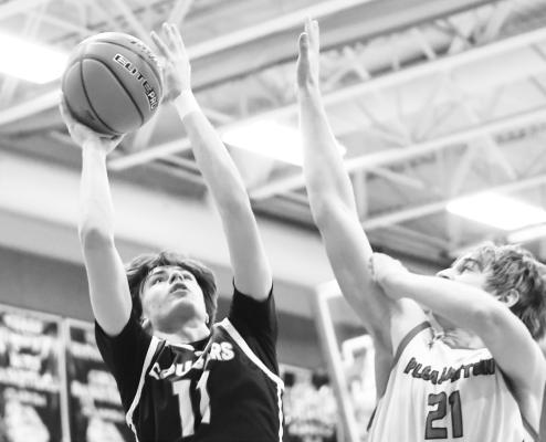 TAE SOTO rises above Pleasanton’s Keiser Dixon on the way to the rim last Tuesday in Pleasanton. Soto finished the game with seven points. Photos by Jordan Coslor