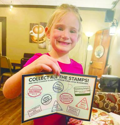 BRECKLYNN SCHULTZ shows off her collection of stamps from the Cairo, Dannebrog, Boelus Passport Program. The program ran from June through early September this year. Courtesy Photo