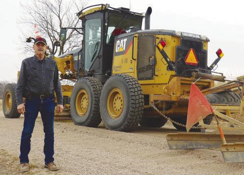 RETIRING HOWARD COUNTY ROADS FOREMAN RAY HURT is pictured near his motor grader on 8th Avenue near the Harold W. Anderson Wildlife Management Area last week. The road was among those most affected by the flooding of 2019. Photo by Michael Rother